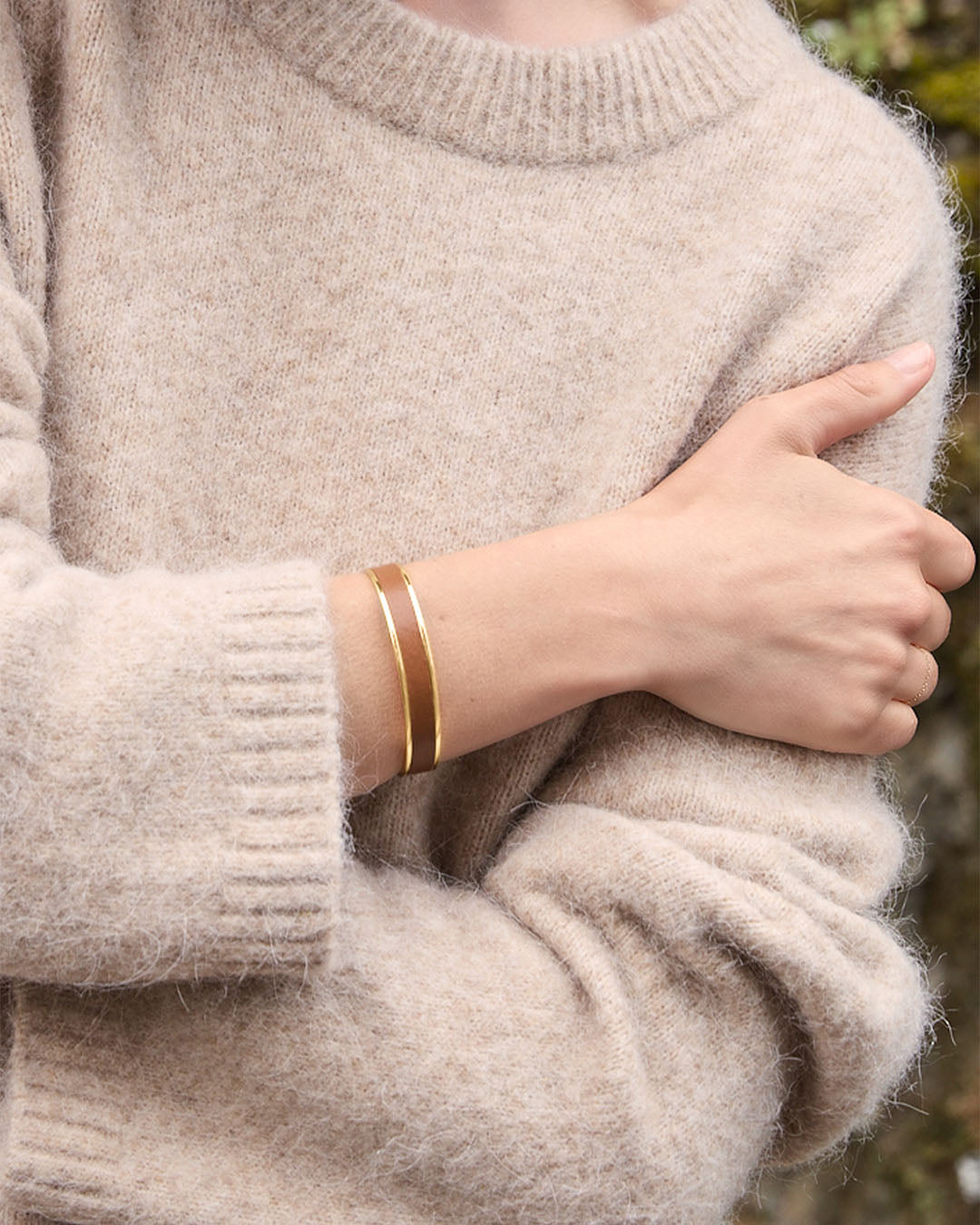 Le bracelet Pacôme Renouard doré et cuir lisse camel, vu porté par notre mannequin.