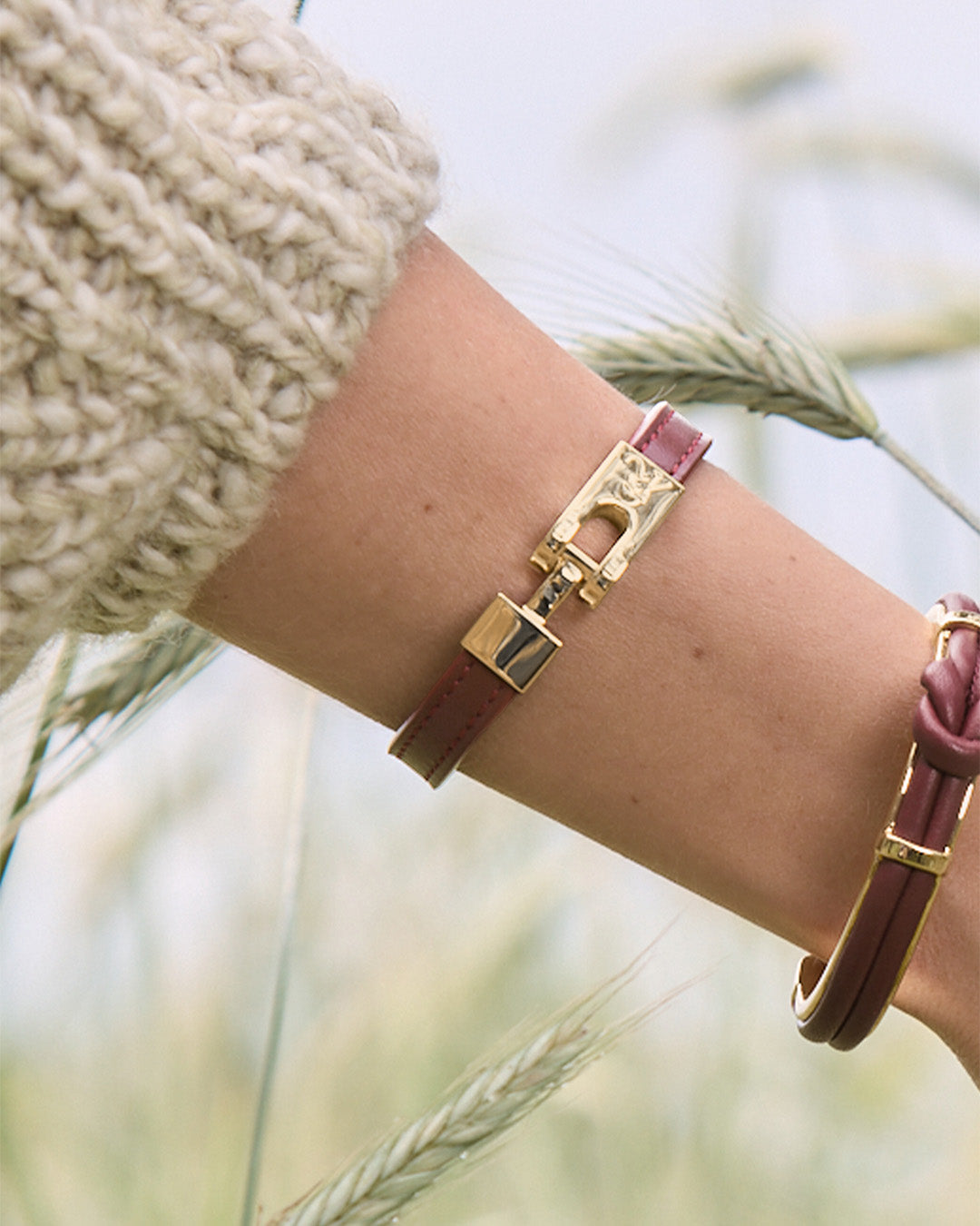 Le bracelet Roméo Renouard en cuir lisse acajou et son fermoir bijou doré pâle, vu porté par notre mannequin.