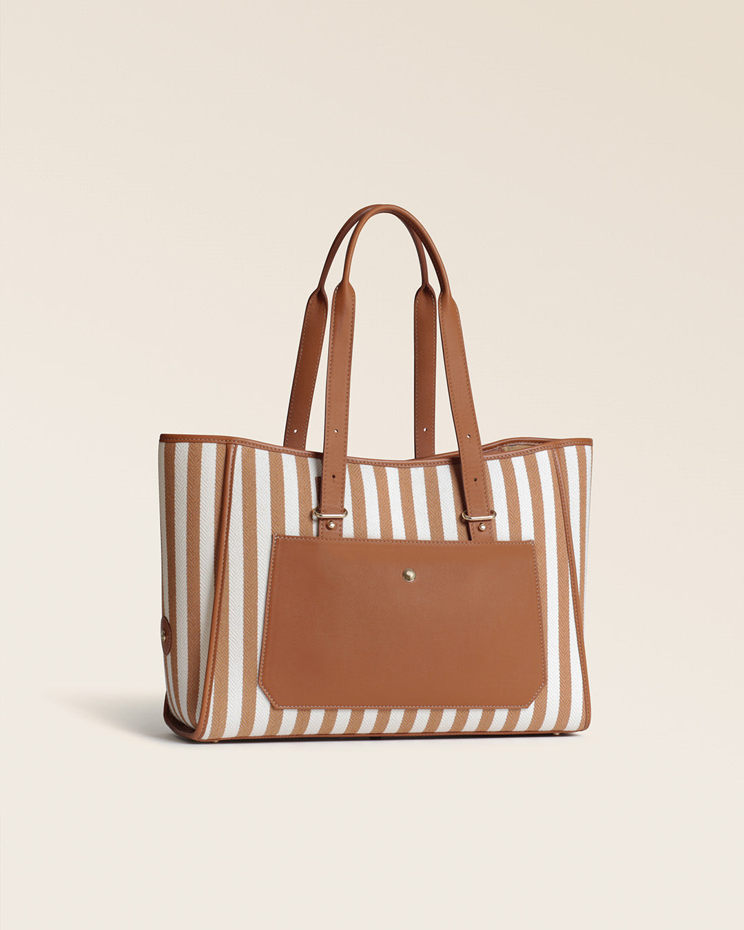 Le sac cabas Marcello Renouard en toile transat et en cuir vintage camel, vu de quart en studio.