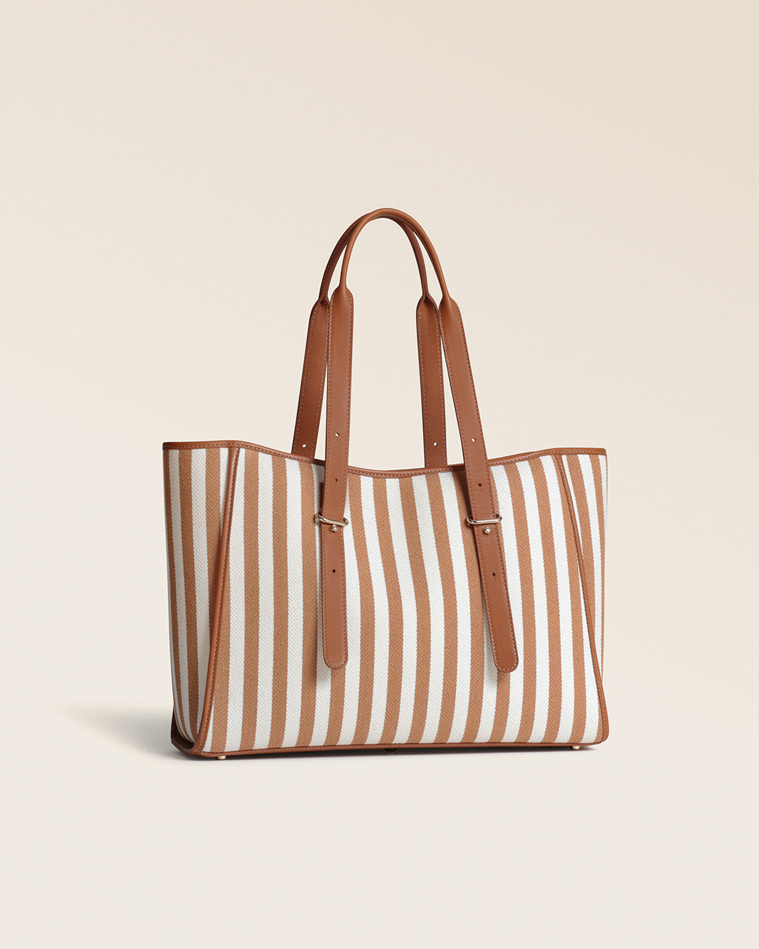 Le sac cabas Marcello Renouard en toile transat et en cuir vintage camel, vu de quart en studio.