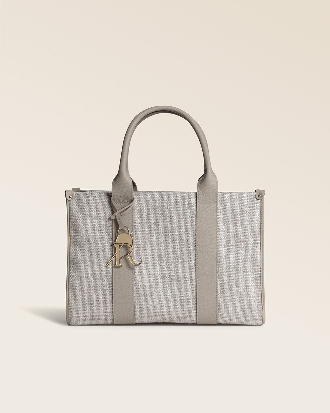 Notre sac cabas Nina Renouard en toile minérale et en cuir façon vigogne corde, vu de face en studio.