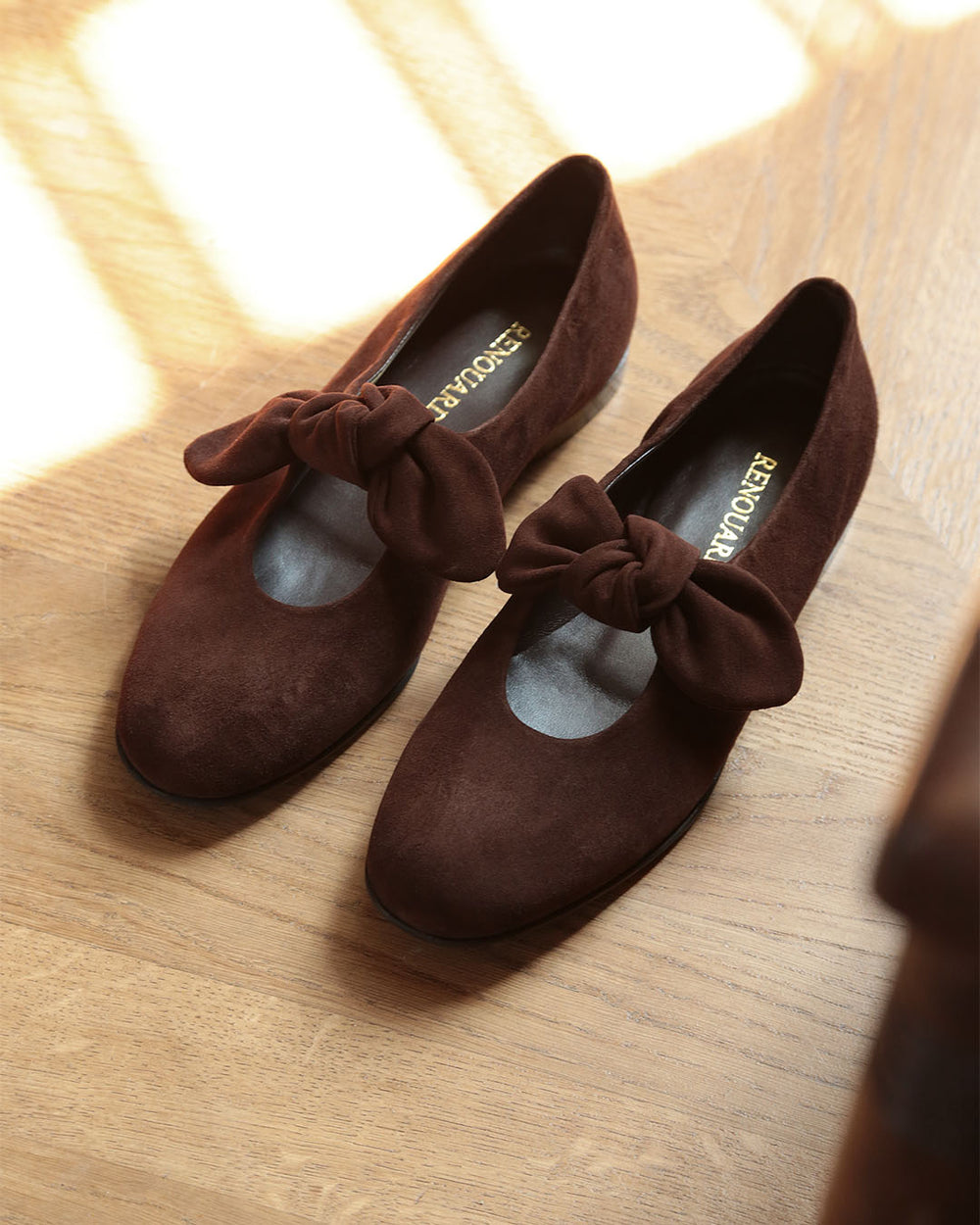 Nos babies Céleste Renouard en cuir nubuck chocolat et leur joli noeud sur le pied, vues en ambiance.