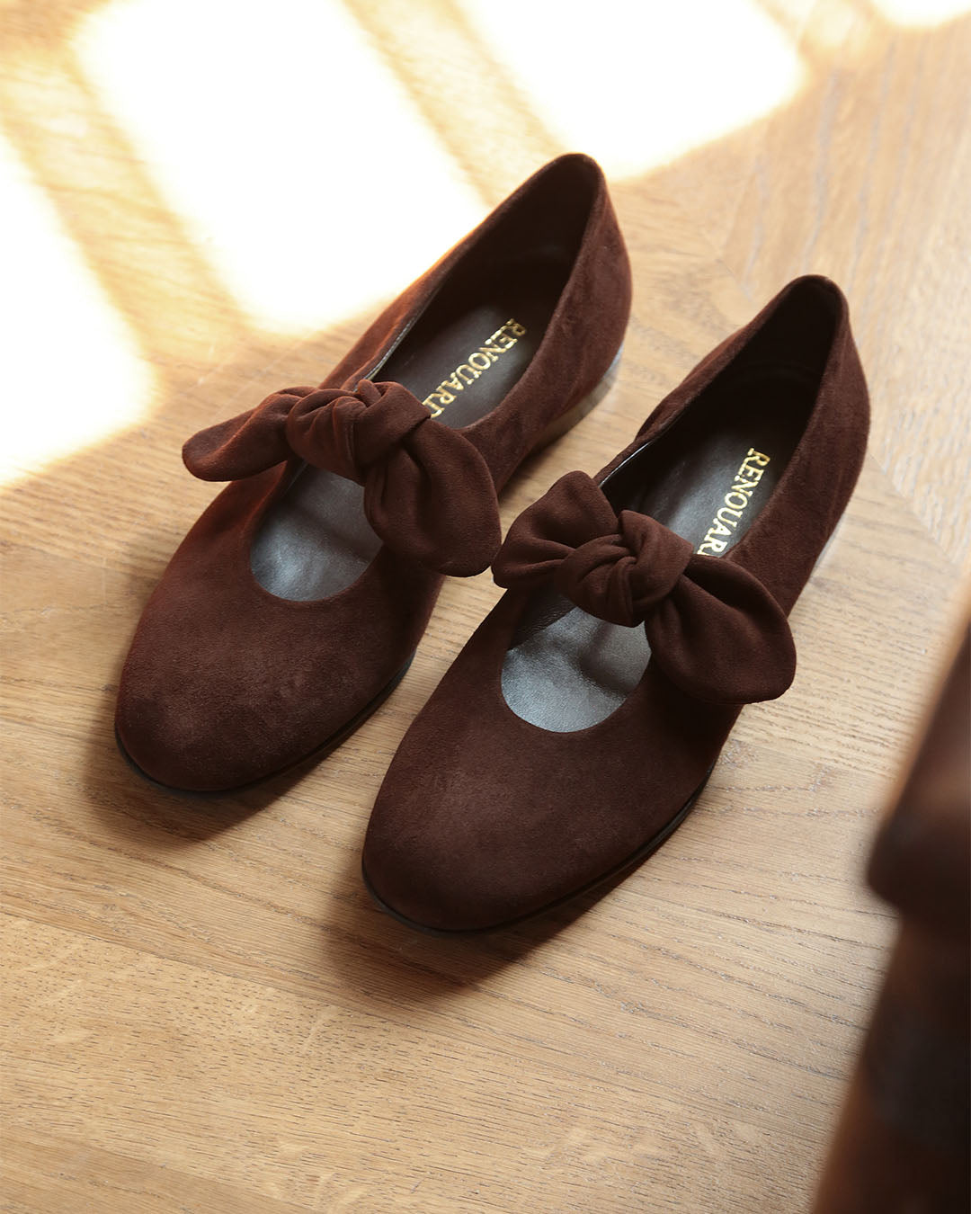 Nos babies Céleste Renouard en cuir nubuck chocolat et leur joli noeud sur le pied, vues en ambiance.