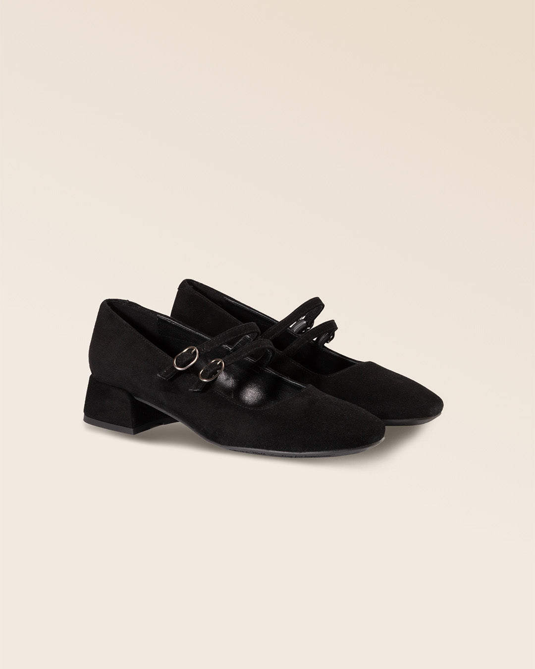 Nos babies Esmée Renouard en cuir nubuck noir et leur double bride sur le pied, vues de quart en studio.