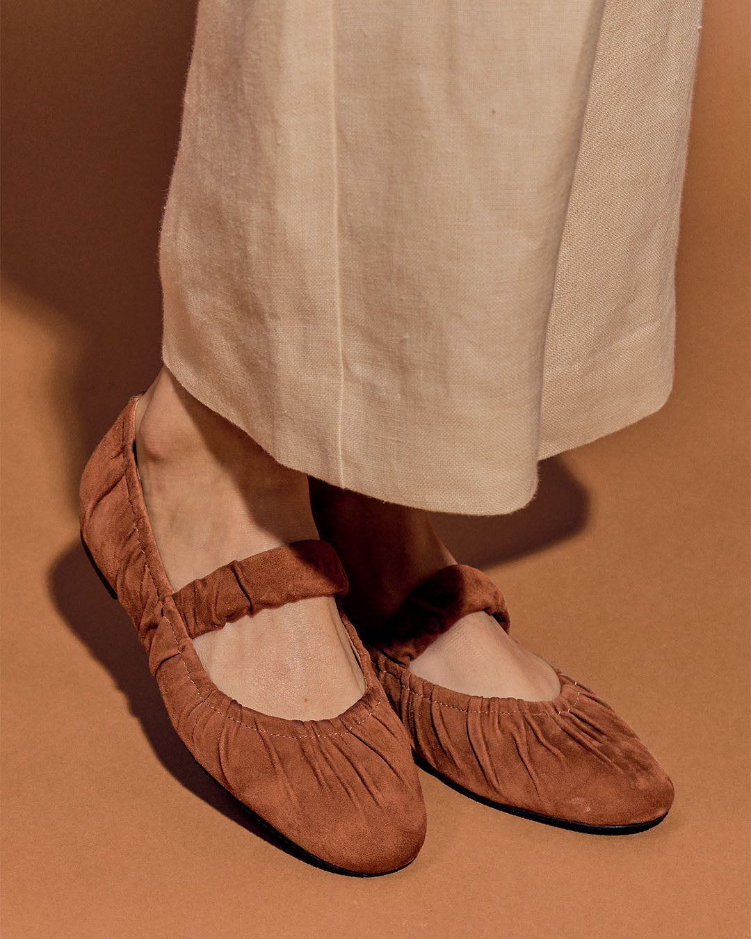 Nos ballerines Ciotat Renouard en cuir nubuck camel, vues portées par un mannequin.