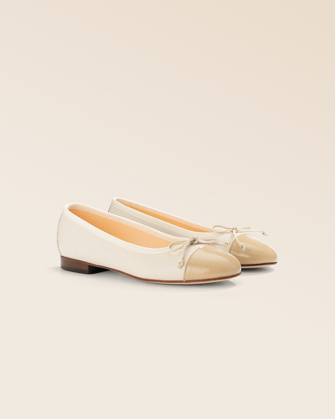 Nos ballerines Friandise Renouard en cuir lisse crème et cuir vernis beige, vues de quart en studio.