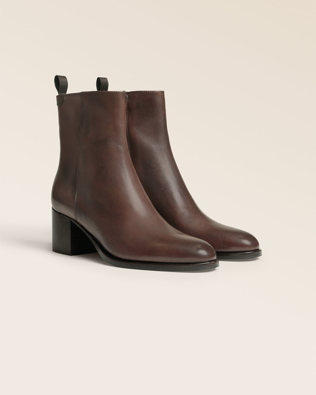 Les boots Justine Renouard en cuir lisse chocolat, vues de quart en studio.