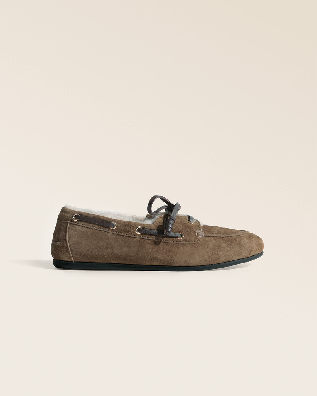 Nos mocassins Marcus Renouard en cuir velours bronze doublés de moumoute confortable et chaude, vus de côté en studio.