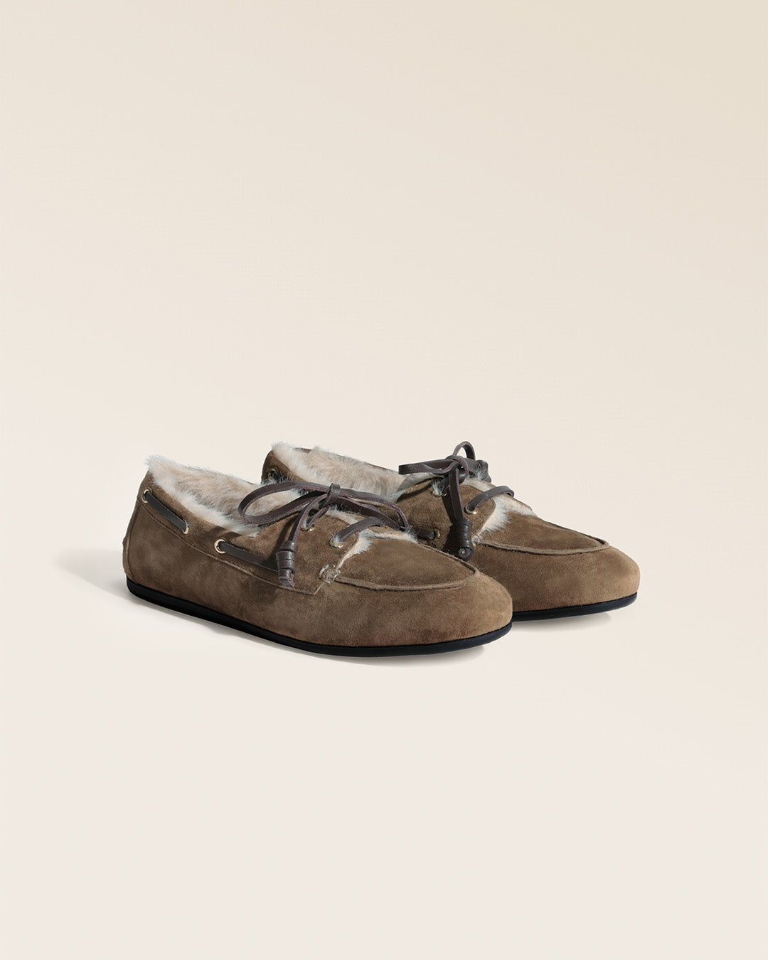 Nos mocassins Marcus Renouard en cuir velours bronze doublés de moumoute confortable et chaude, vus de quart en studio.