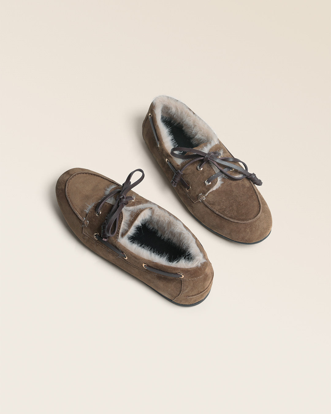 Nos mocassins Marcus Renouard en cuir velours bronze doublés de moumoute confortable et chaude, vus en studio.