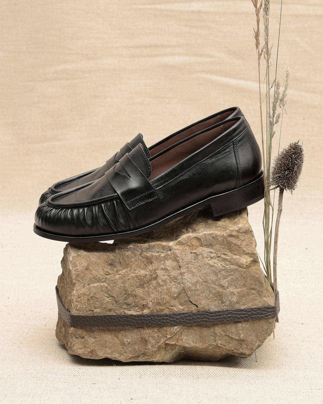 Les mocassins Pergola Renouard en cuir lisse noir, vus de côté en ambiance.