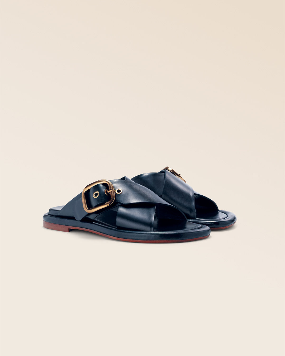Nos mules Anaïs Renouard en cuir lisse bleu marine, vues de quart en studio.