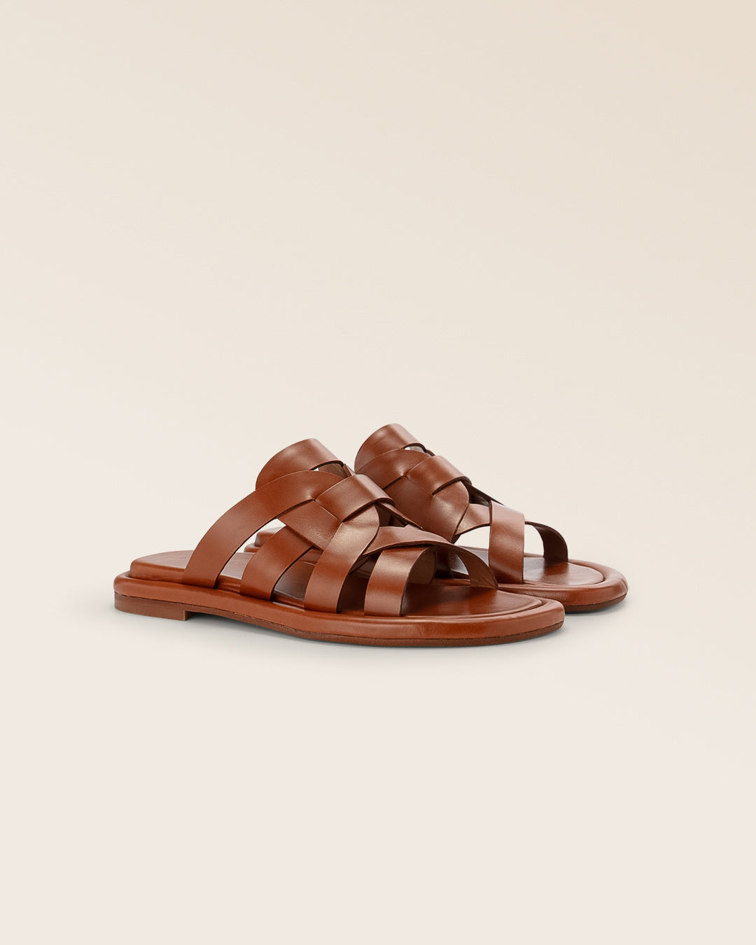 Nos mules Anthéa Renouard en cuir lisse gold, vues de quart en studio.