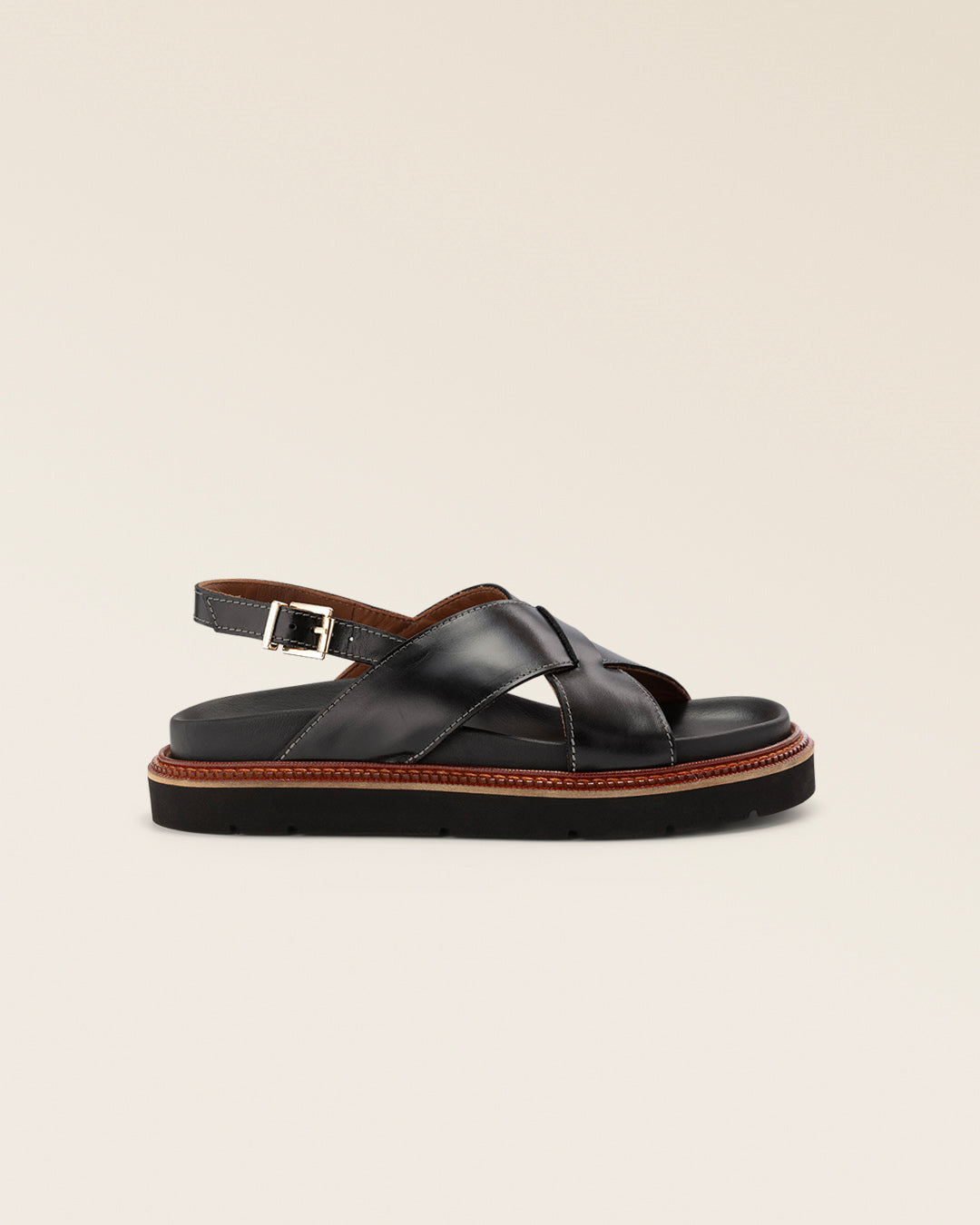 Les nu-pieds Olympe noirs en cuir lisse, vue de coté en studio.