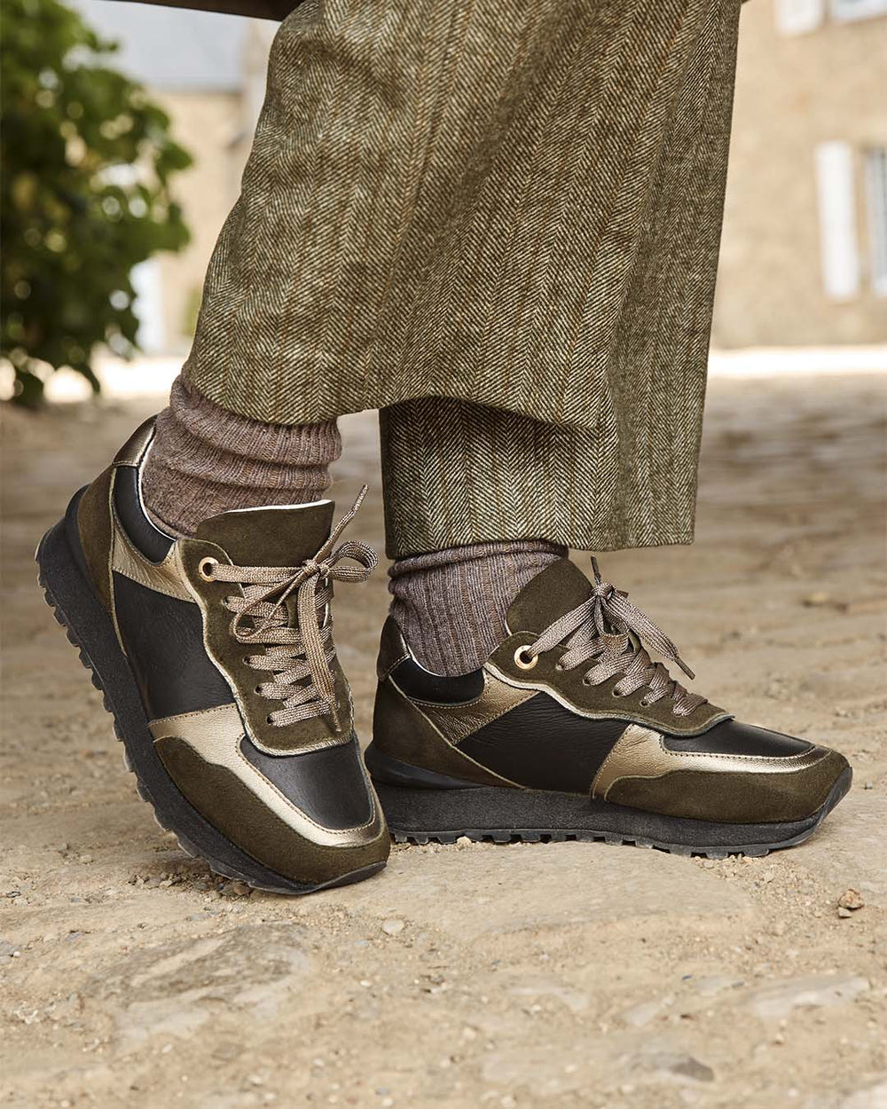 Nos sneakers Albane Renouard en cuir nubuck kaki et lisse noir, vues portées par notre mannequin.