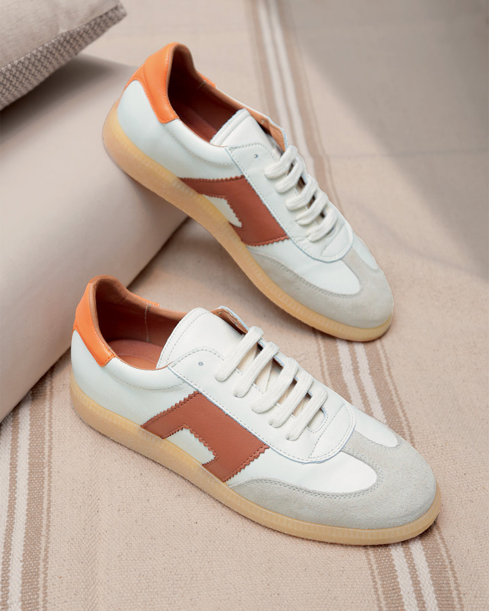 Nos sneakers Clara Renouard en cuir lisse craie, taupe, camel et orange ; vues en ambiance.