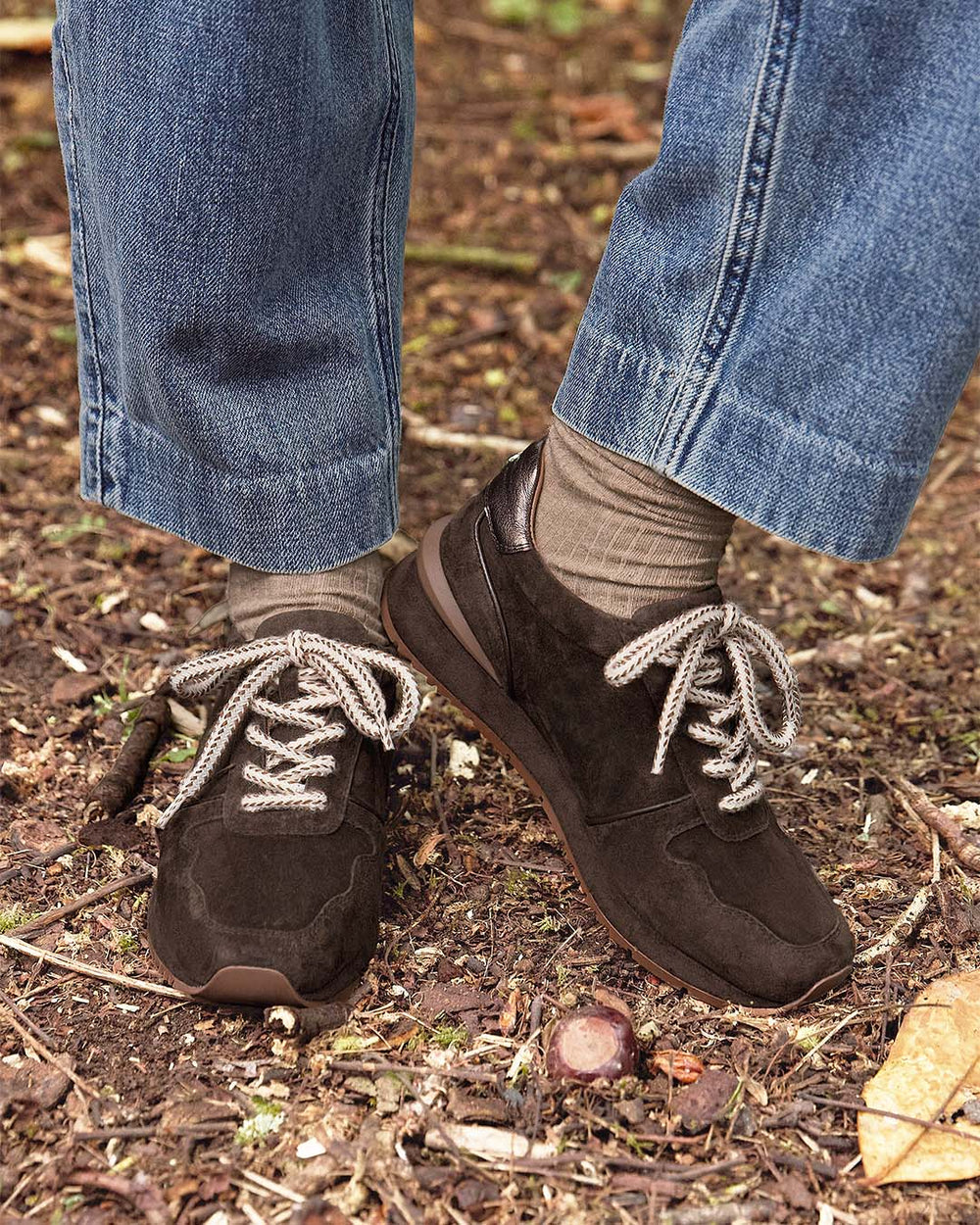 Nos sneakers Jude Renouard en cuir velours chocolat et lacet beige, vues portées par notre mannequin.