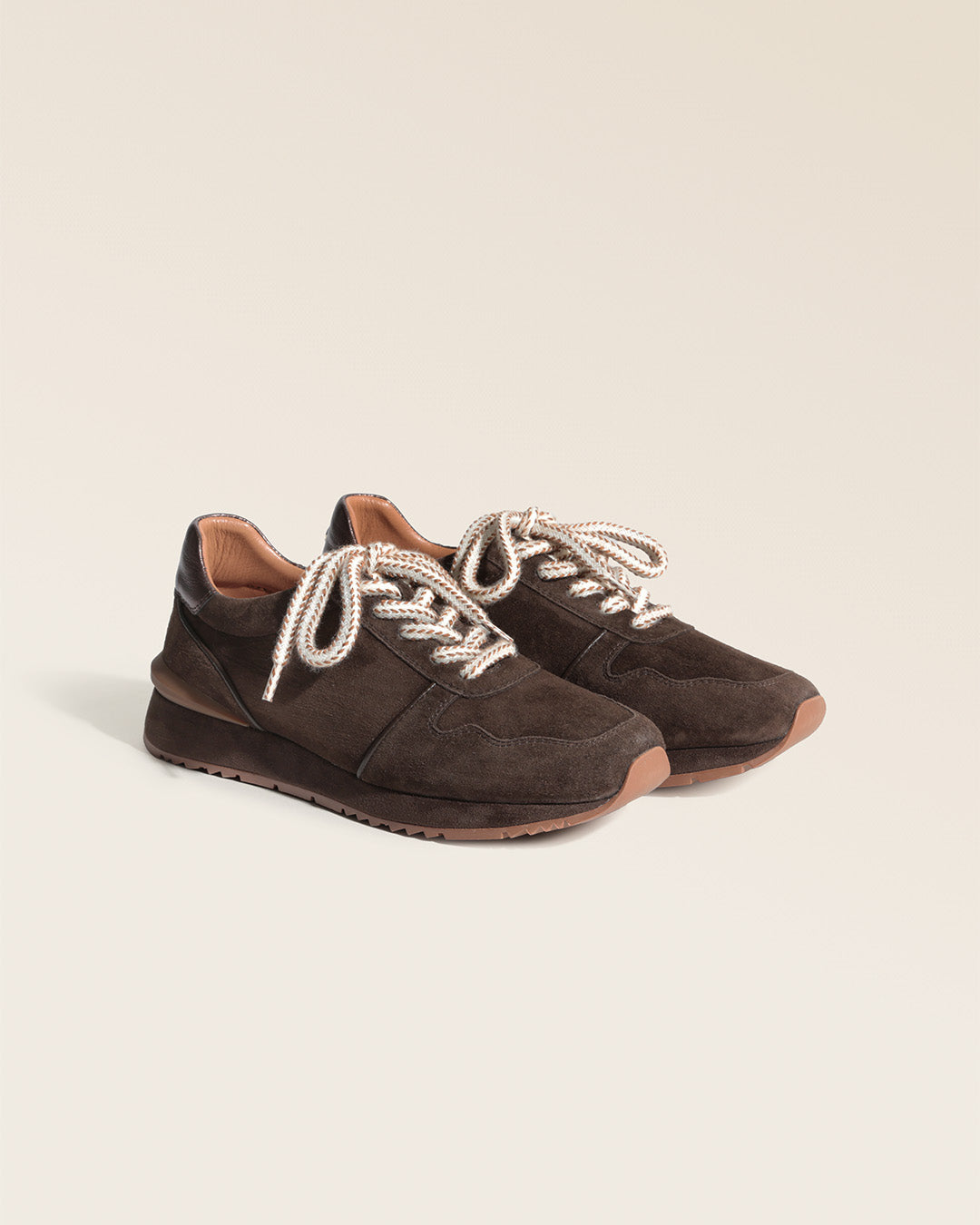Nos sneakers Jude Renouard en cuir velours chocolat et lacet beige, vues de quart en studio.
