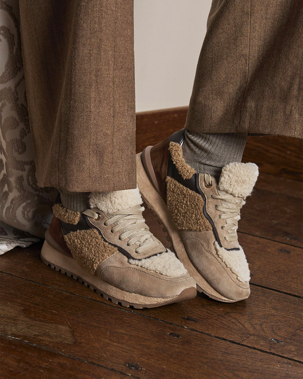 Nos sneakers Montana Renouard en cuir nubuck beige, bouclette fauve et cuir lisse chocolat, vues portées par notre mannequin.