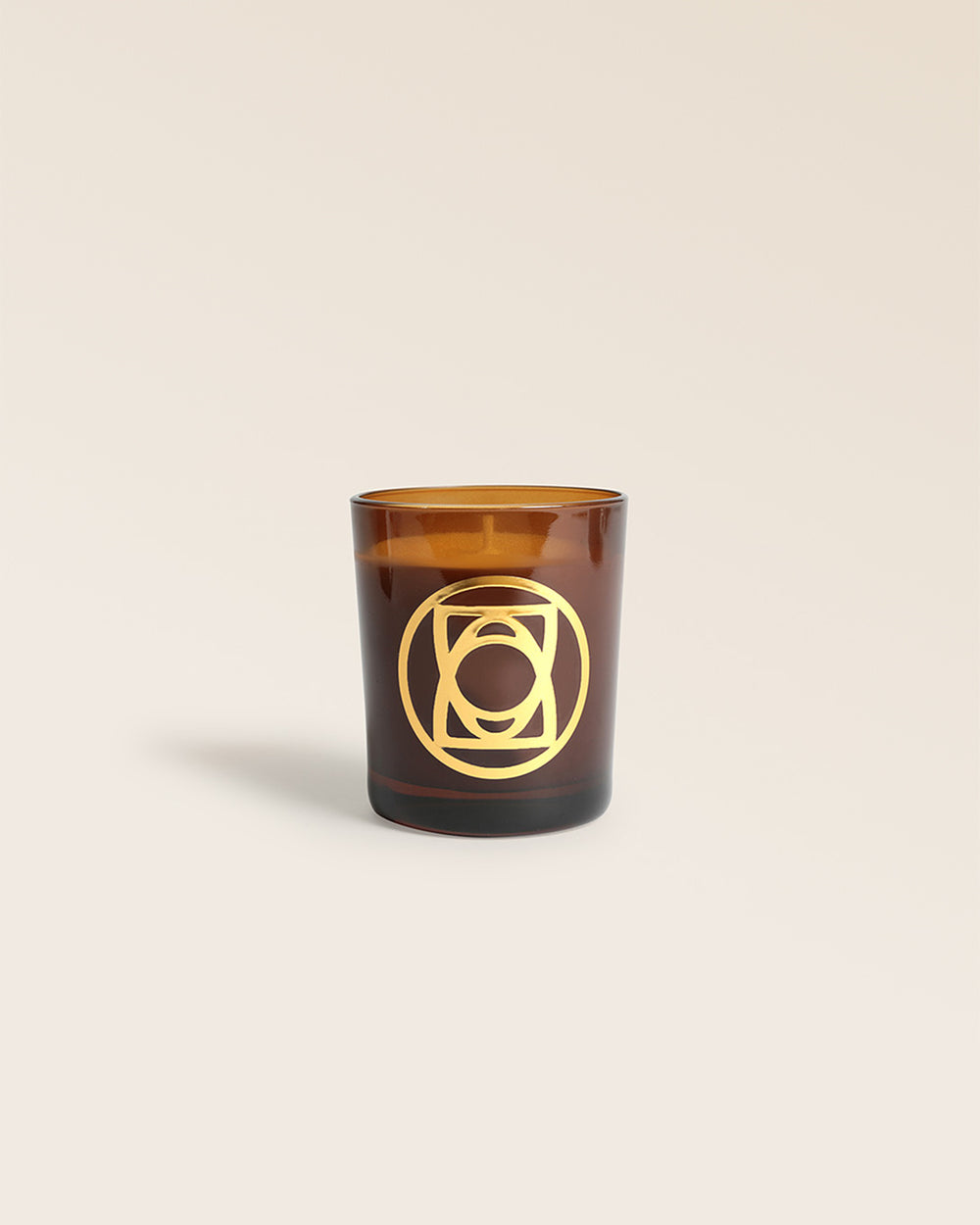 Notre bougie Écorce de Cuir Renouard, et son verre ambrée, vue de face en studio.