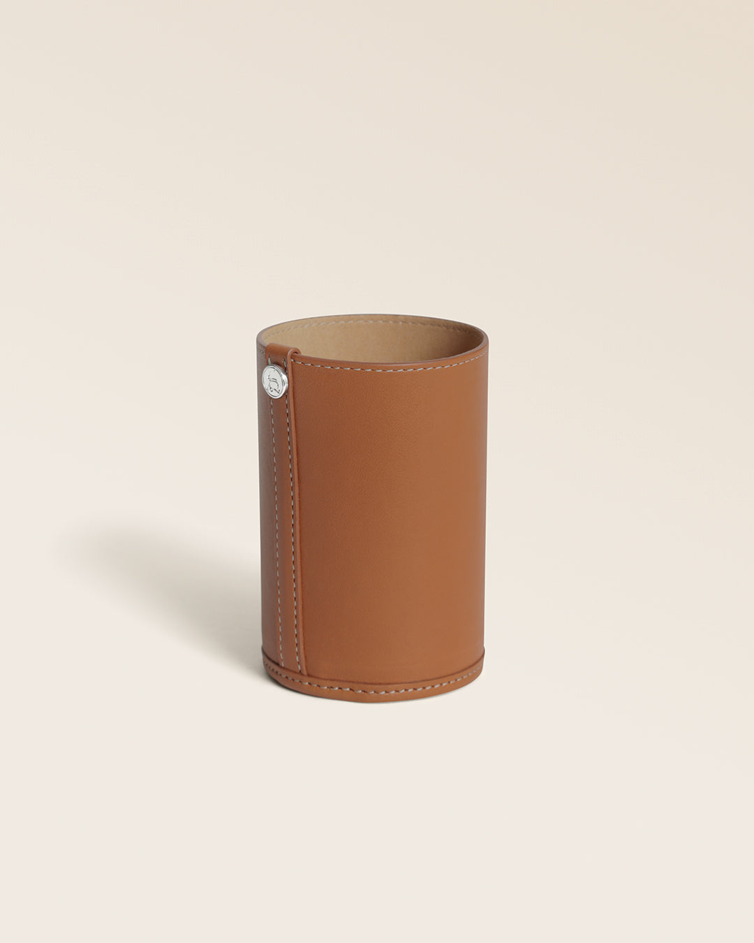 Notre pot à crayons Renouard en cuir vintage camel, vu de quart en studio.