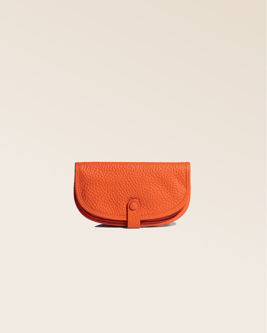 Notre étui à bijoux en cuir façon vigogne orange vu de face en studio.