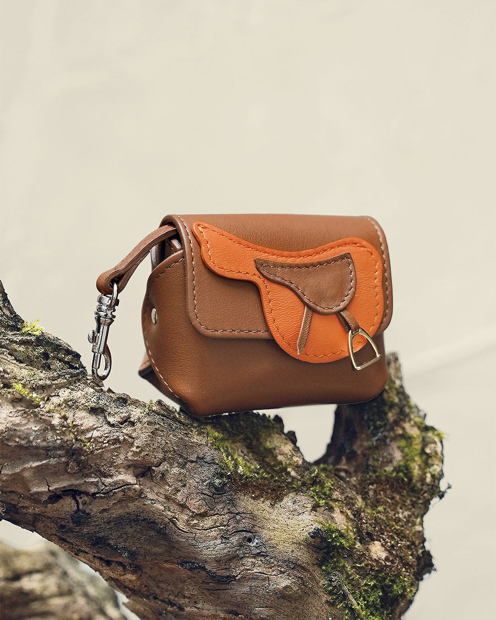 L'étui Casaque Renouard en cuir lisse camel et orange, vu de quart en ambiance.