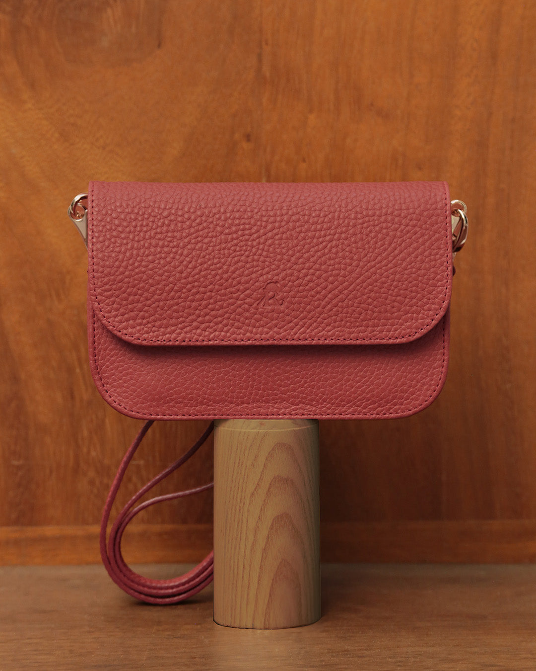 Notre pochette Coralie Renouard en cuir façon vigogne terracotta, vue de face en ambiance.