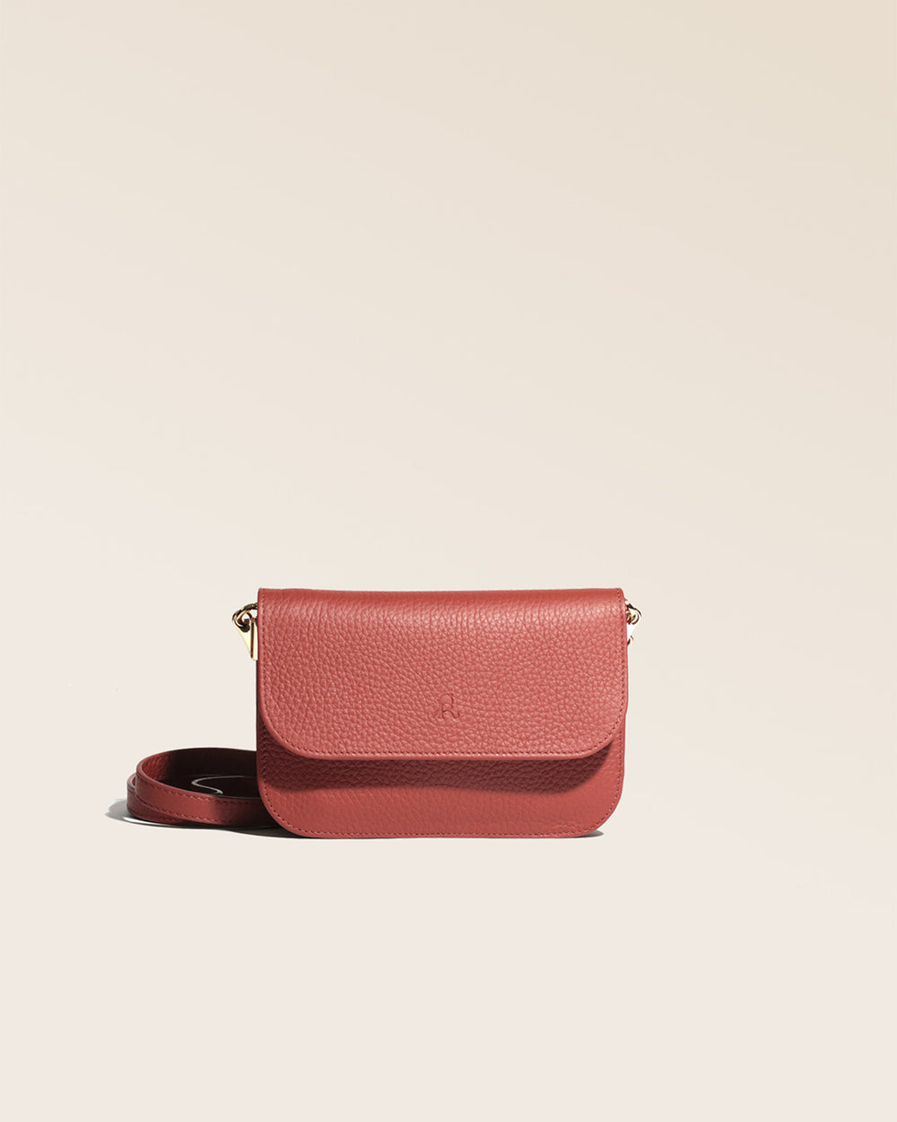 Notre pochette Coralie Renouard en cuir façon vigogne terracotta, vue de face en studio.