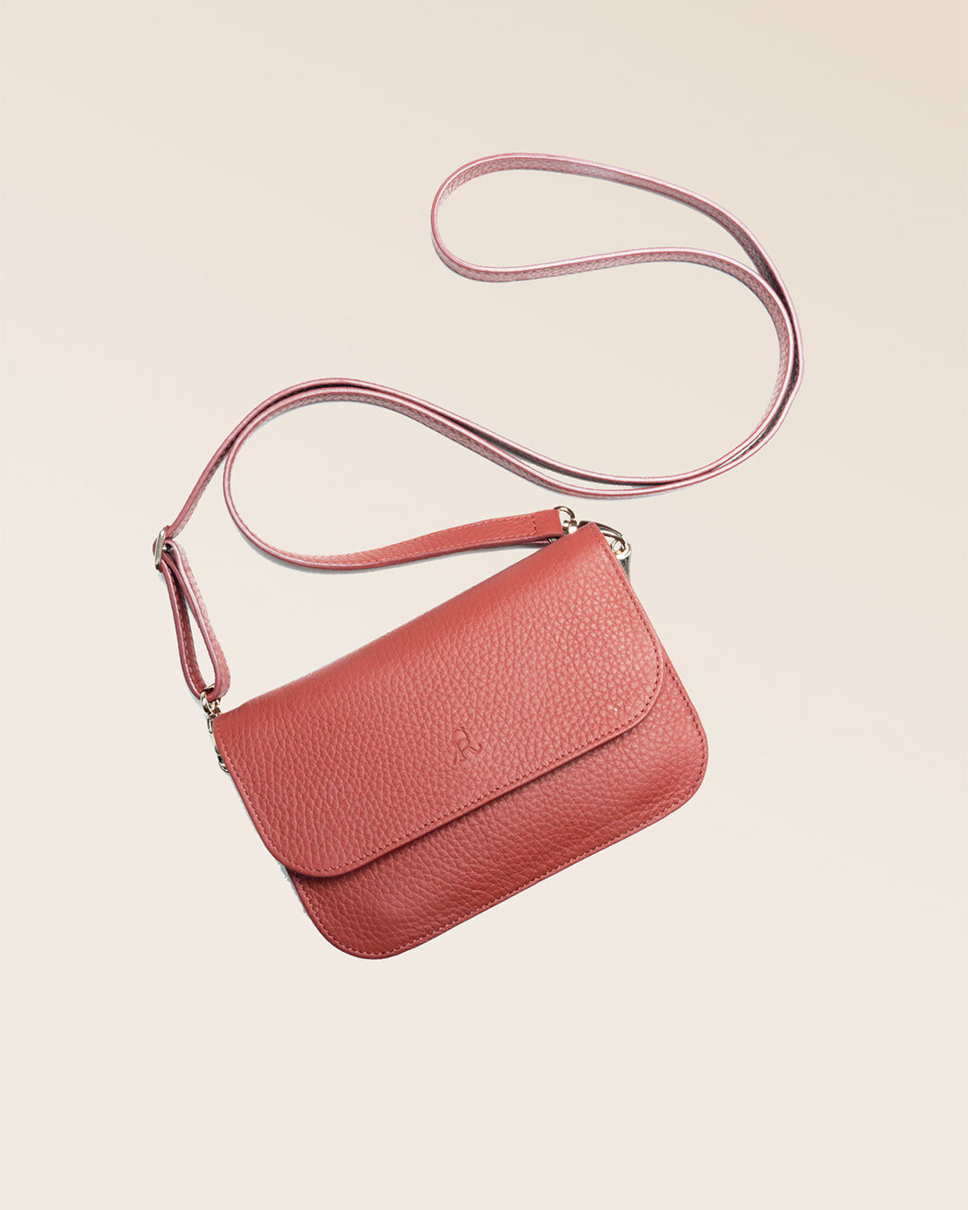 Notre pochette Coralie Renouard en cuir façon vigogne terracotta, vue en ambiance en studio.