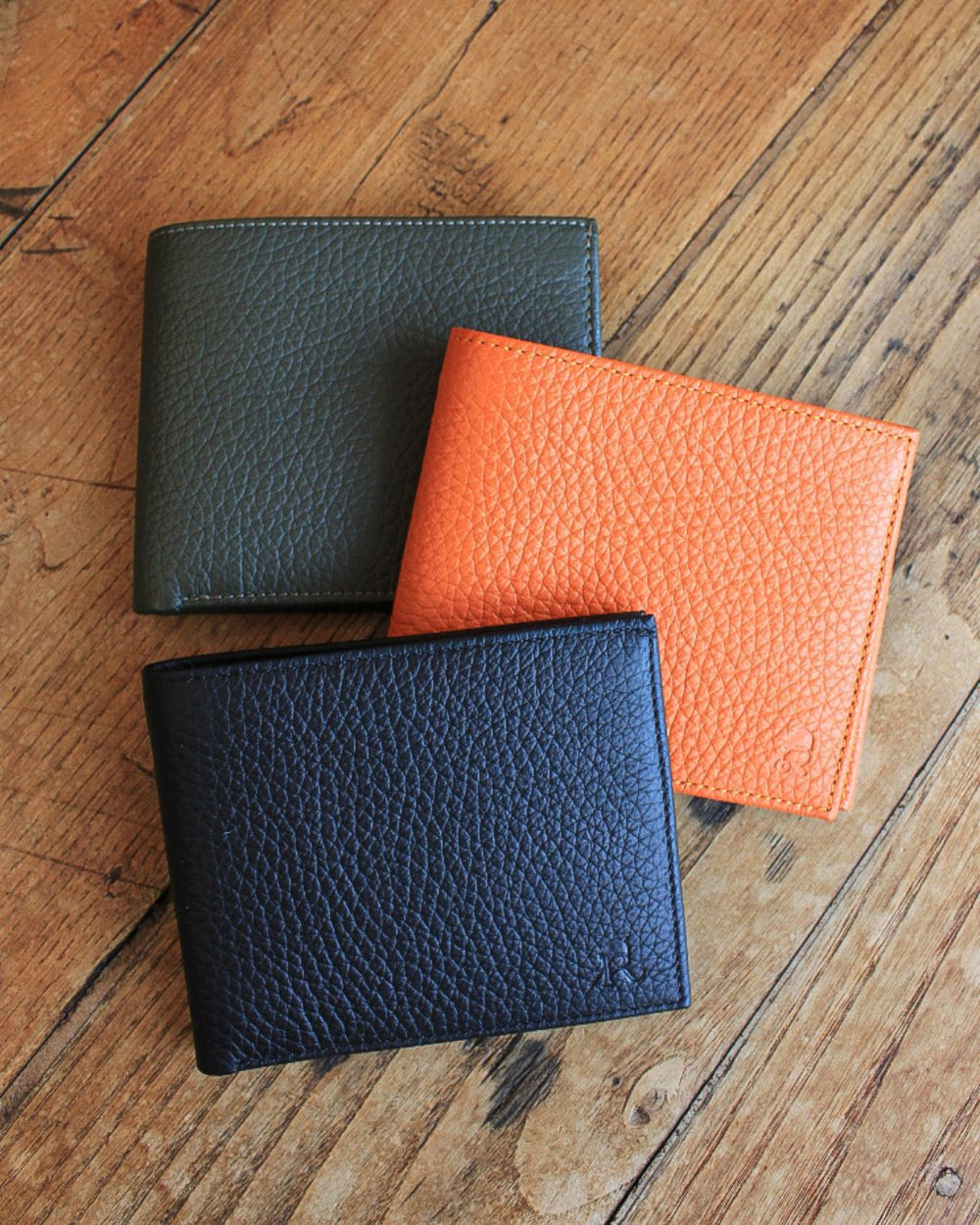 Notre porte-billets CB en cuir façon vigogne orange, kaki et noir vu de face en ambiance.