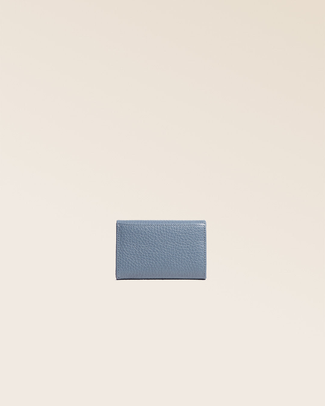Notre porte-monnaie Alma en cuir façon vigogne bleu cobalt vu de dos en studio.