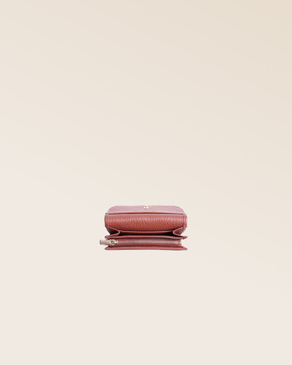 Notre porte-monnaie Alma en cuir façon vigogne terracotta vu du dessus en studio.