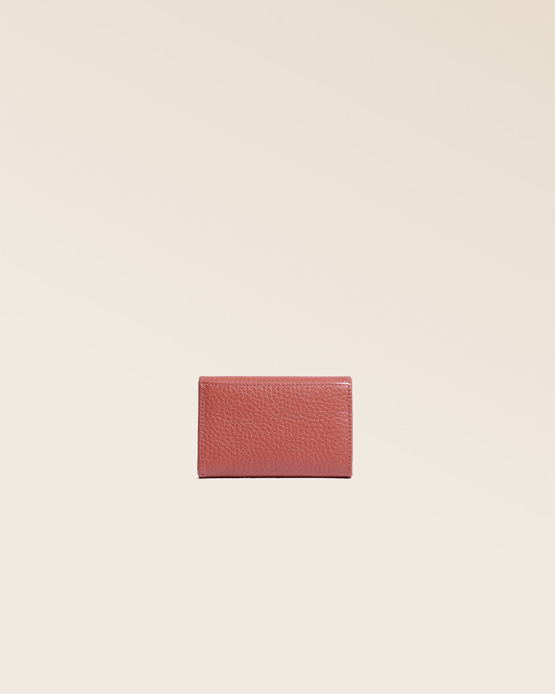 Notre porte-monnaie Alma en cuir façon vigogne terracotta vu de dos en studio.
