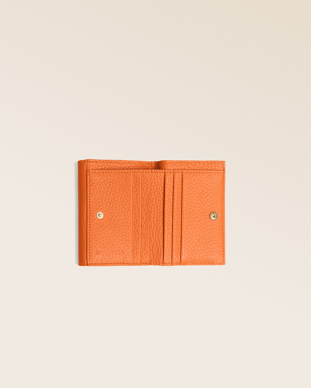 Le porte-monnaie Ariana Renouard, en cuir façon vigogne orange, vu complètement ouvert en studio.