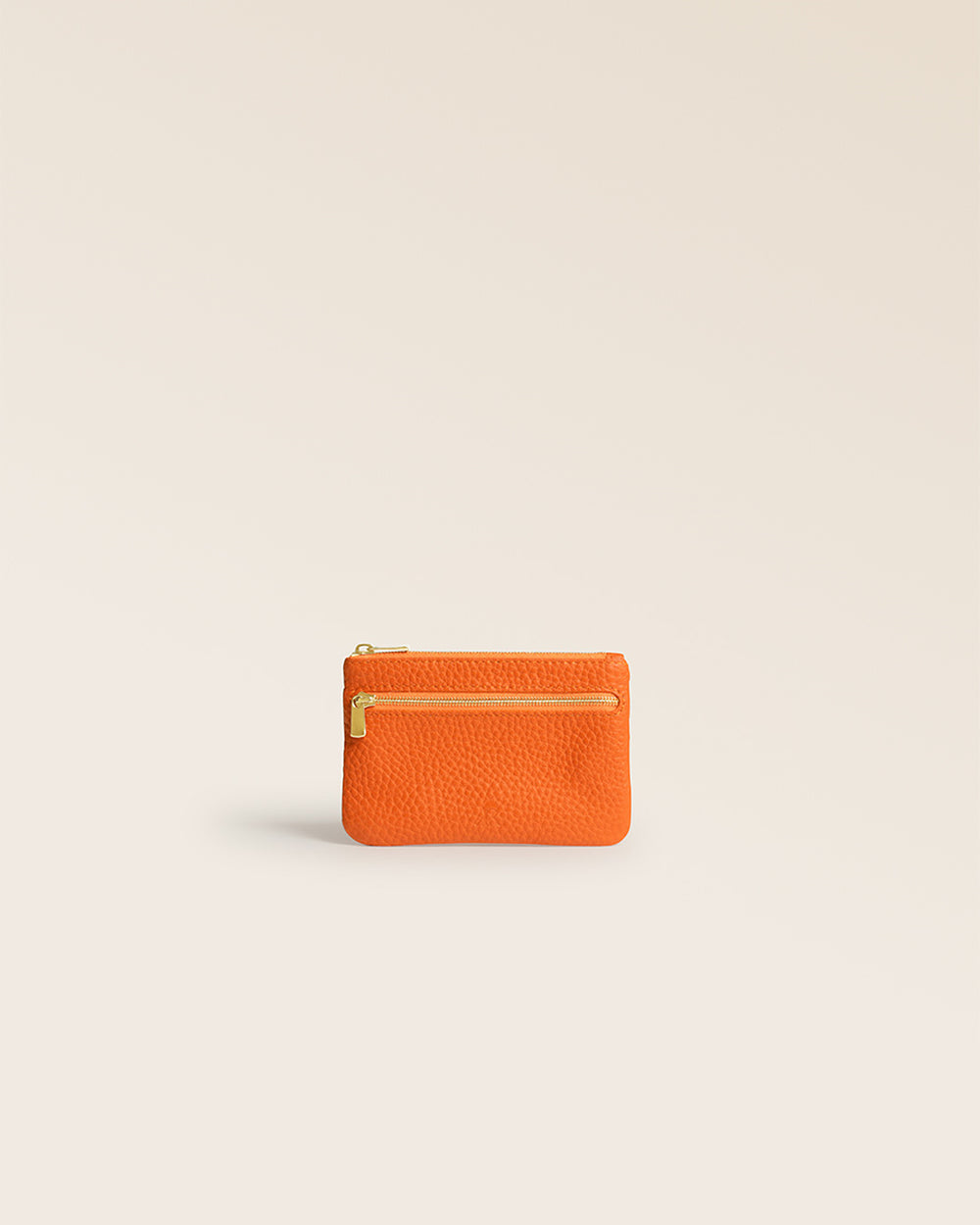 Notre porte-monnaie Capucine Renouard en cuir façon vigogne orange vu de face en studio.