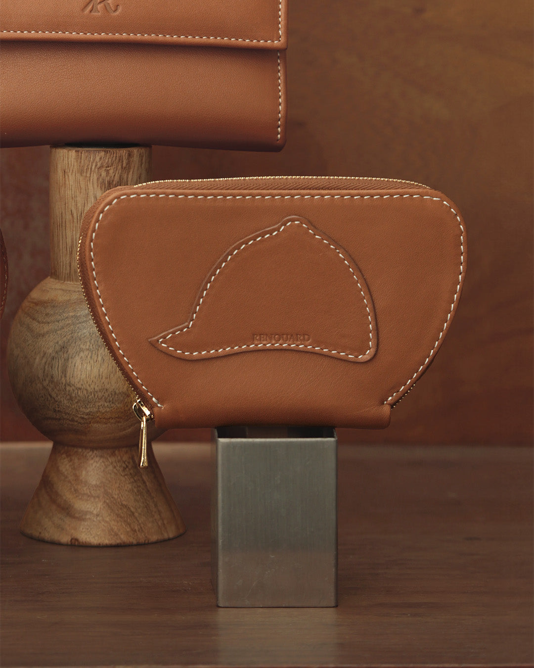 Notre porte-monnaie Galop Renouard en cuir vintage camel, vu de face en ambiance.