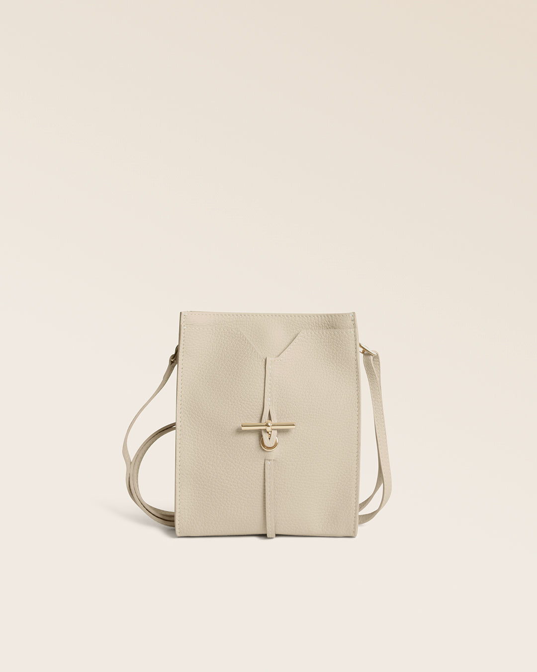 Notre pochette Aglaé Renouard en cuir façon vigogne crème, vue de face en studio.