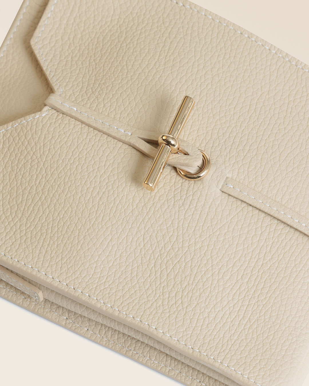 Notre pochette Aglaé Renouard en cuir façon vigogne crème, vue de près en studio.