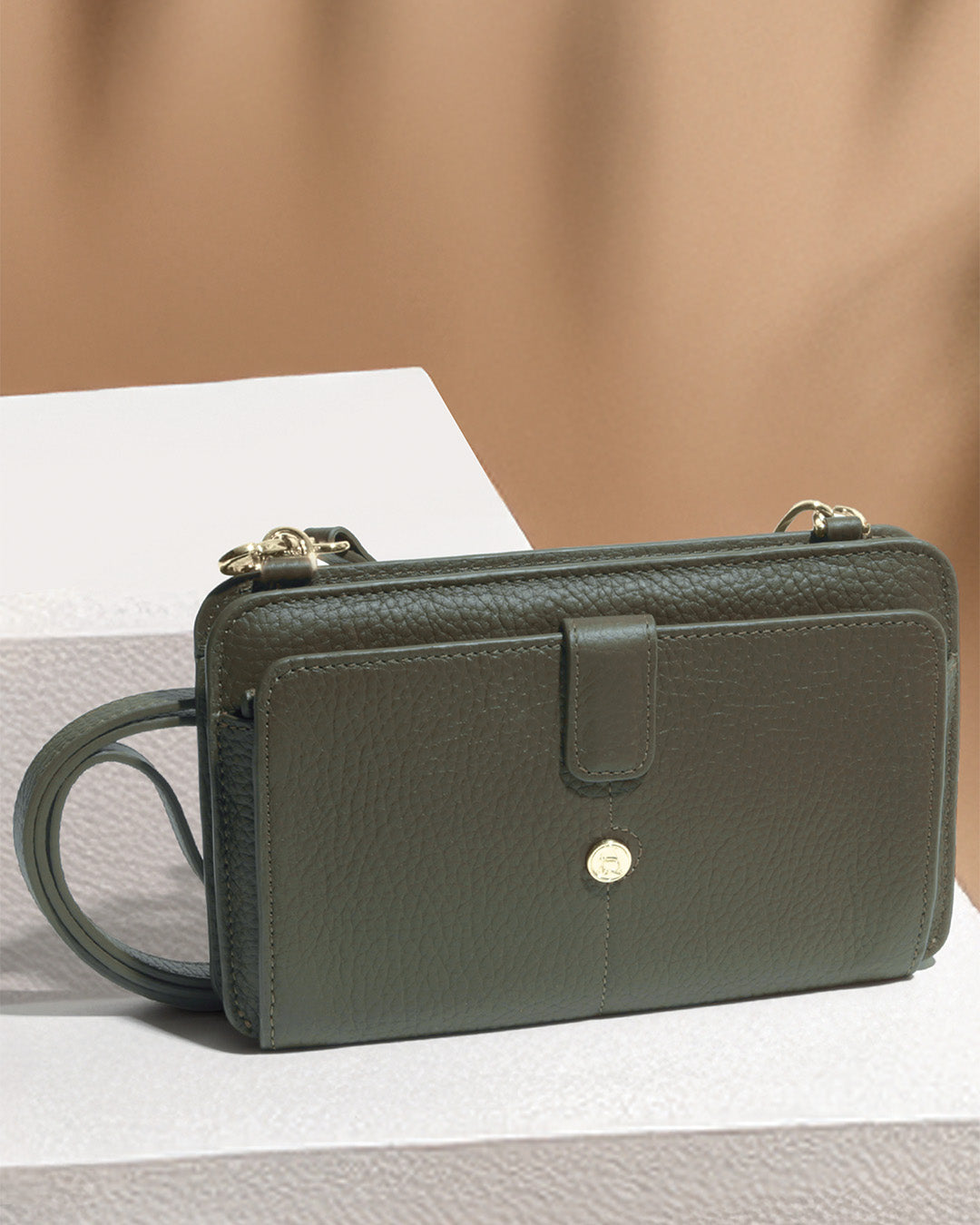 Notre pochette Manolo Renouard en cuir façon vigogne kaki, vue de face en ambiance.