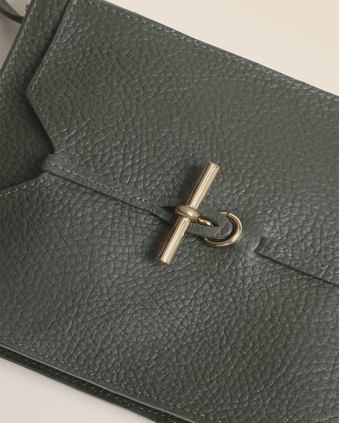 La pochette Aglaé Renouard, en cuir façon vigogne kaki, vue en détails en studio.