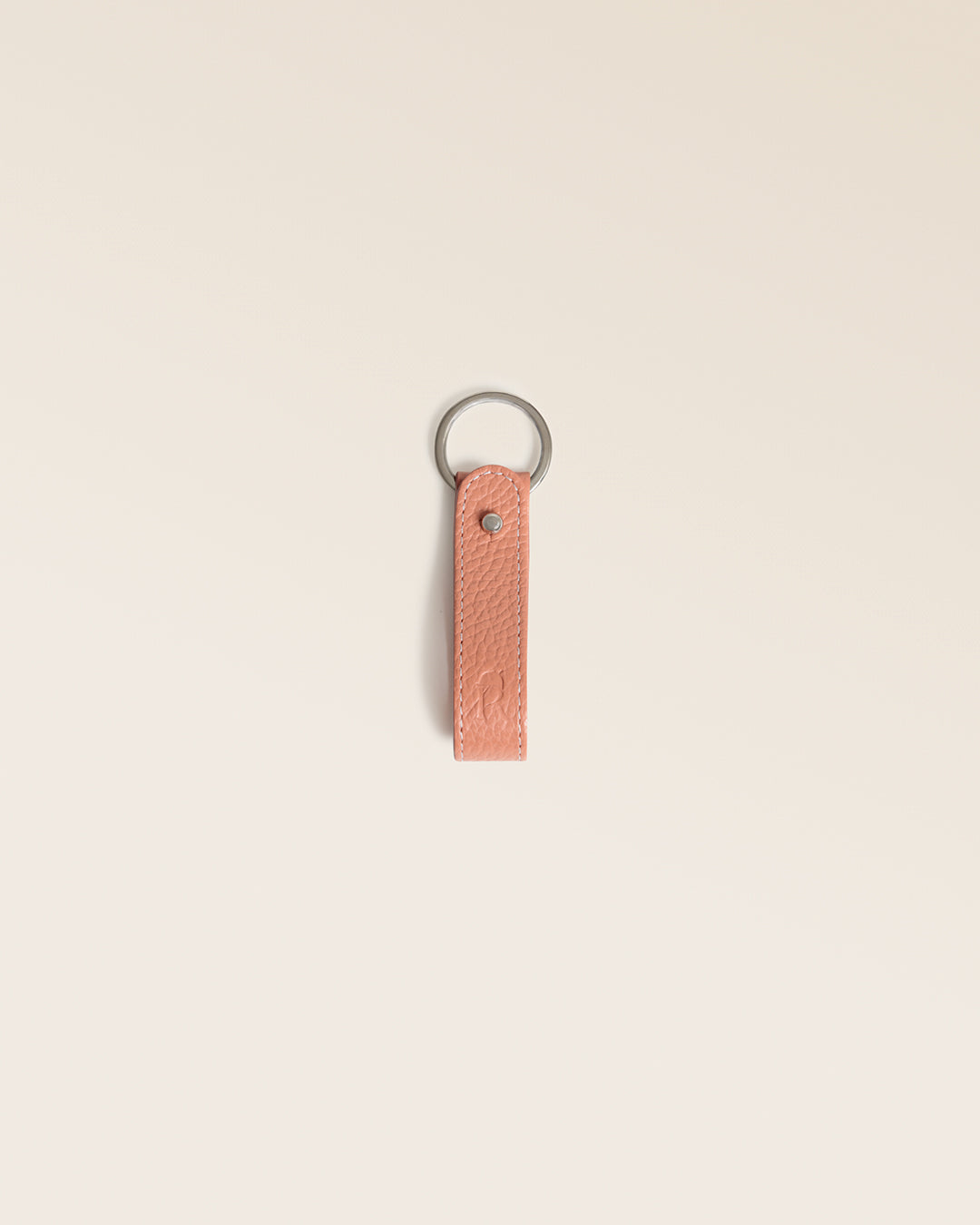 Notre porte-clés Léon Renouard en cuir façon vigogne pêche, vu de face en studio.