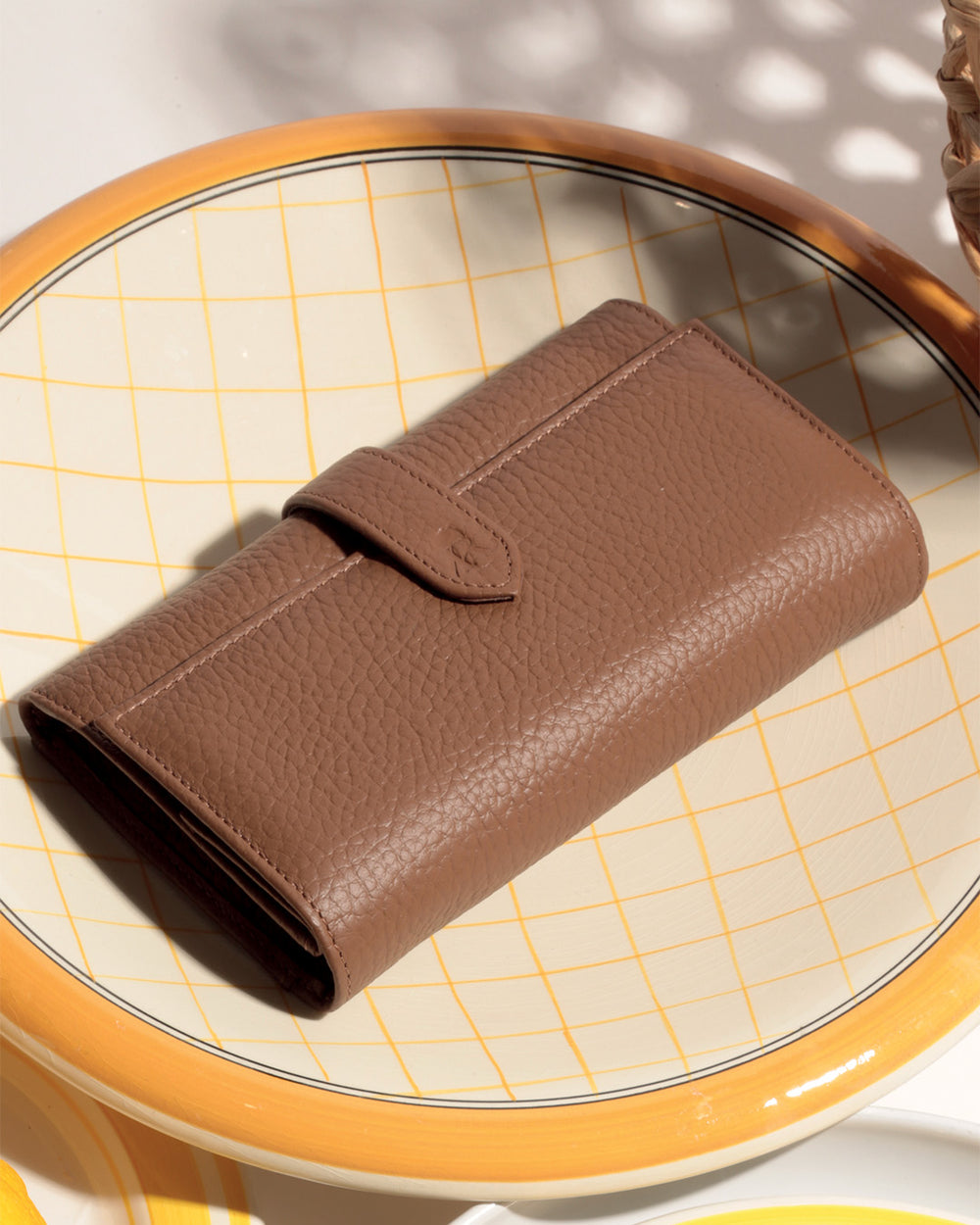 Notre porte-monnaie Adèle Renouard en cuir façon vigogne fauve, vu en ambiance. 