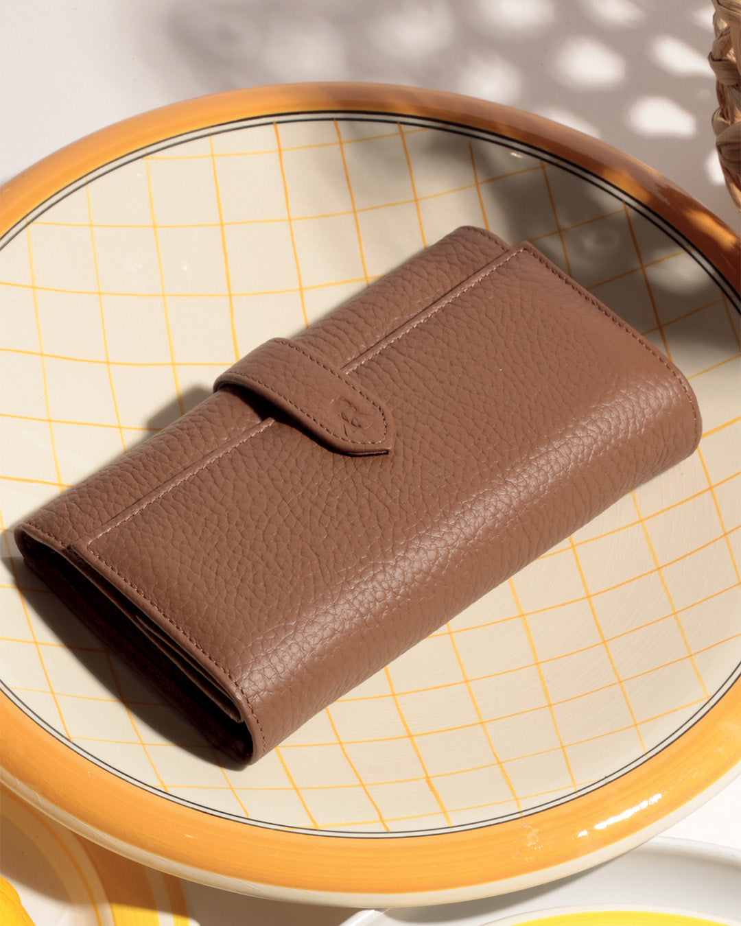 Notre porte-monnaie Adèle Renouard en cuir façon vigogne fauve, vu en ambiance. 