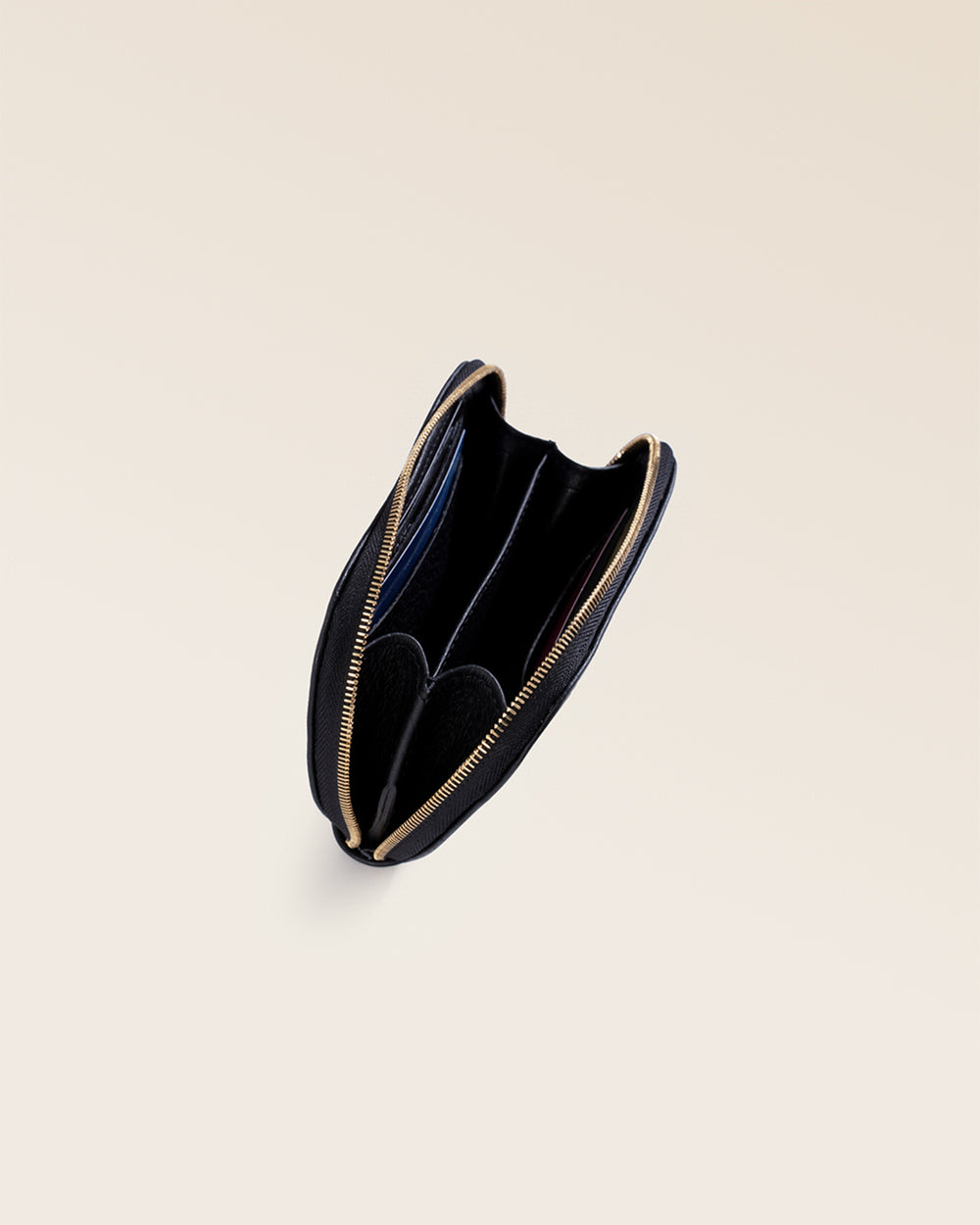 Notre porte-monnaie Galop Renouard en cuir façon vigogne noir, vu de l'intérieur en studio.