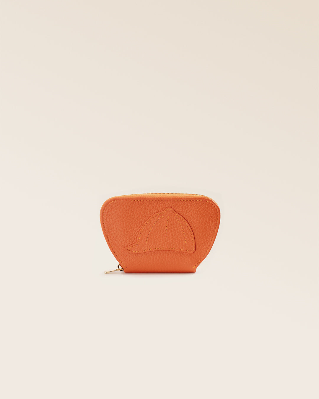 Notre porte-monnaie Galop Renouard, en cuir façon vigogne orange, vu de face en studio.