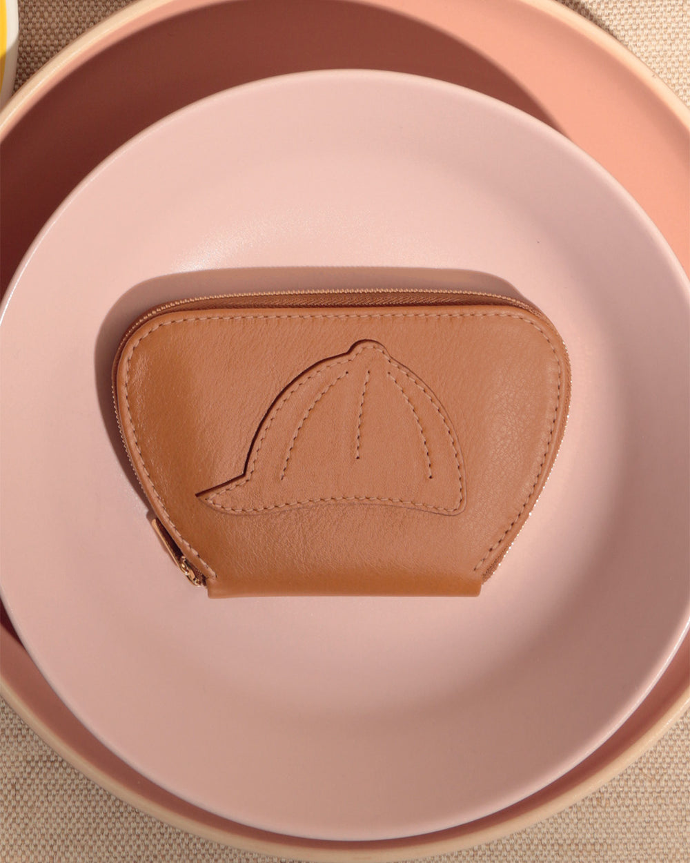 Notre porte-monnaie Galop Renouard en cuir vintage camel, vu en ambiance. 