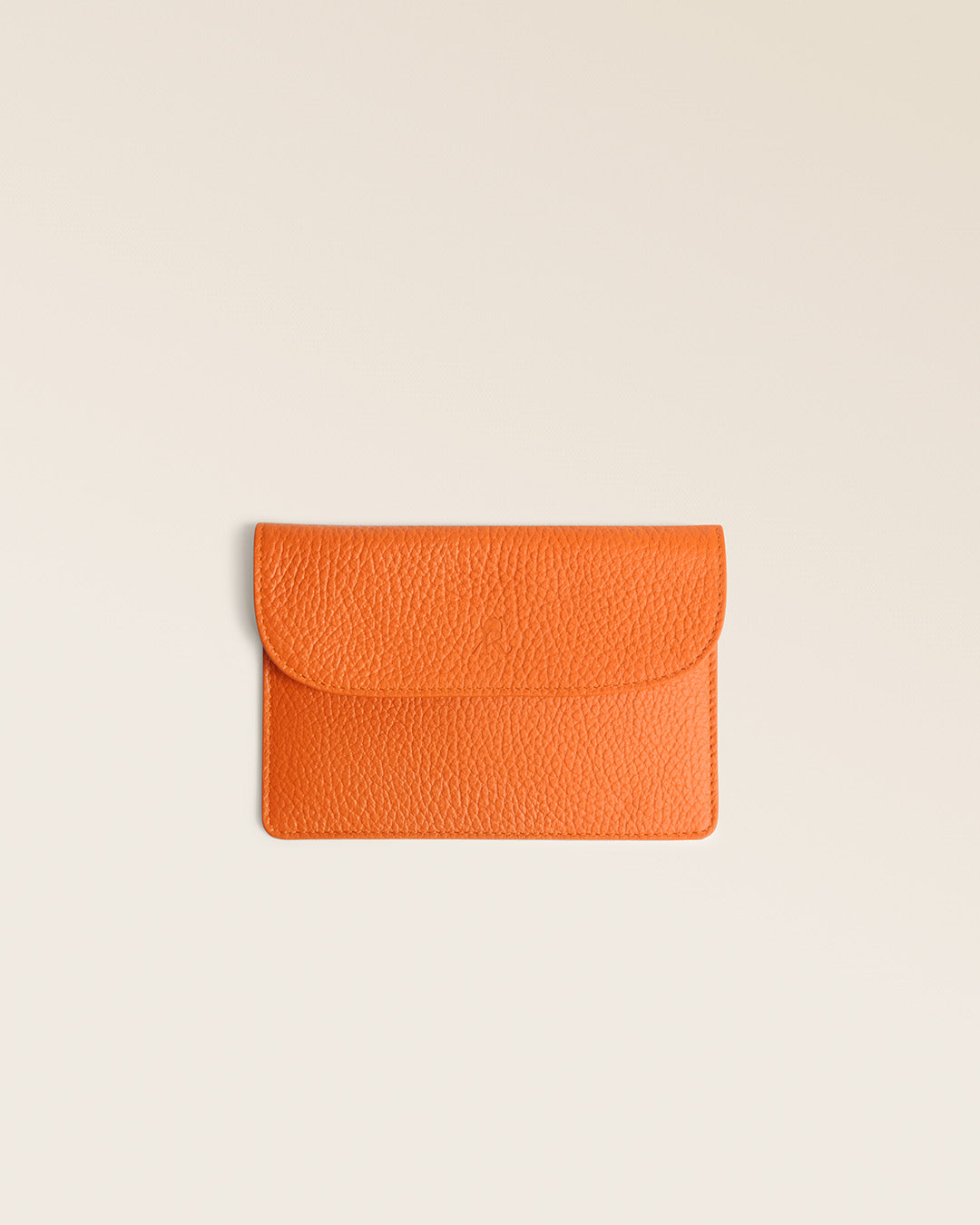 Our Aurore paperweight in orange vicuña-style leather, seen from the front in the studio.