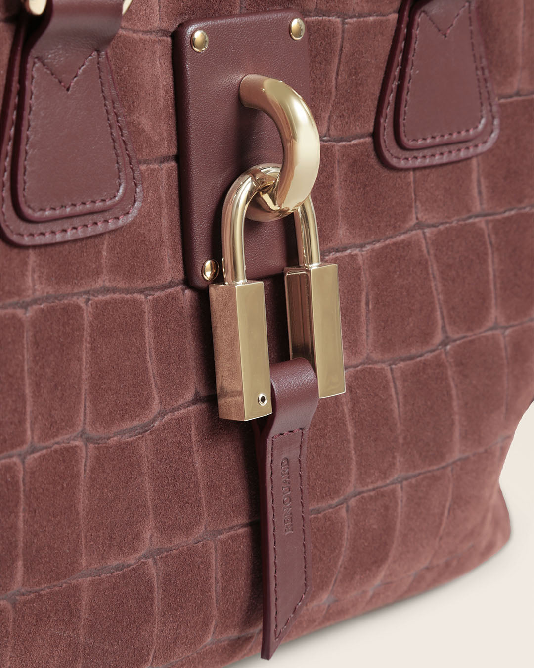 Le sac Mini New-York Renouard en cuir veau velours façon croco acajou et accessoires dorés, vu de près en studio.