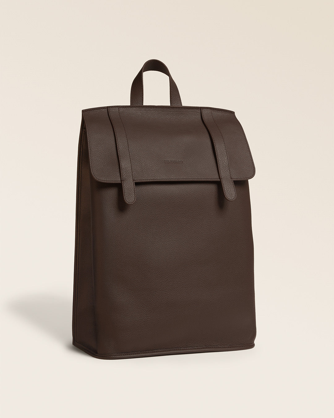 Le sac à dos Alex Renouard en cuir façon vigogne chocolat, vu de quart en studio.